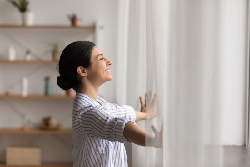 Why Ductless Is the Way to Go - Woman Looks Out the Window.