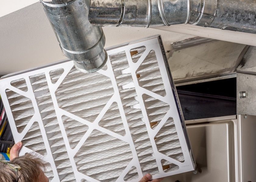 Handyman inspects a filter from a home furnace