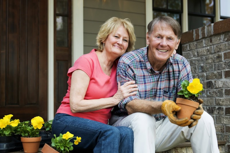 Why Buying a Heat Pump Instead of a Furnace Makes Sense. Photo of a senior couple sitting on their porch.