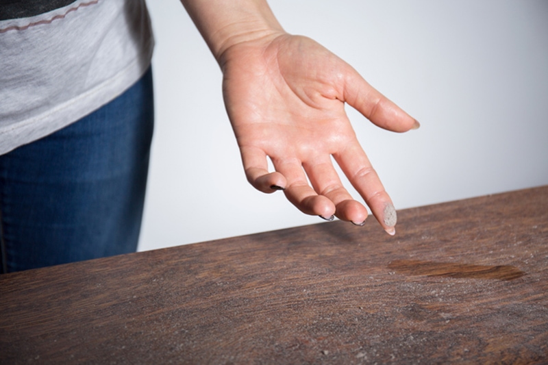 Hand wiping dust off table